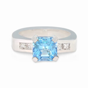 Ein Ring in Weißgold 750/- mit einem hellblauen Aquamarin in Santa Maria Farbe und seitlichen Princess-Diamanten als Begleiter.